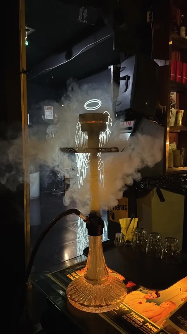 Hookah alight in a darkened venue, smoke lit from below