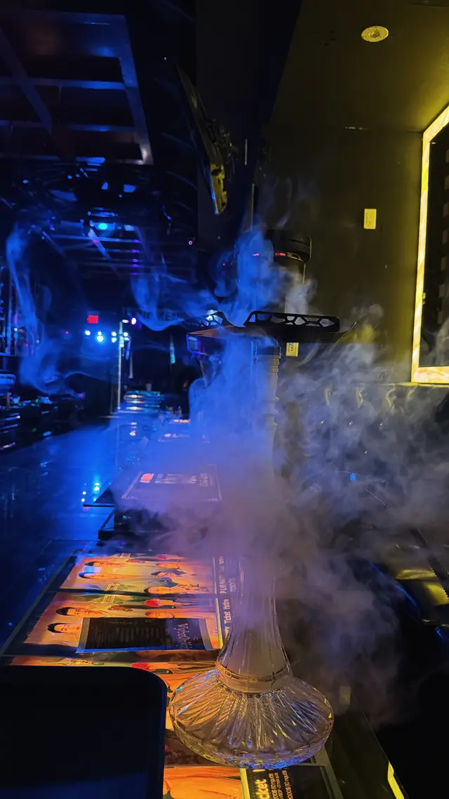 Hookah set up on the bar of a low-lit lounge, smoke drifting across the counter