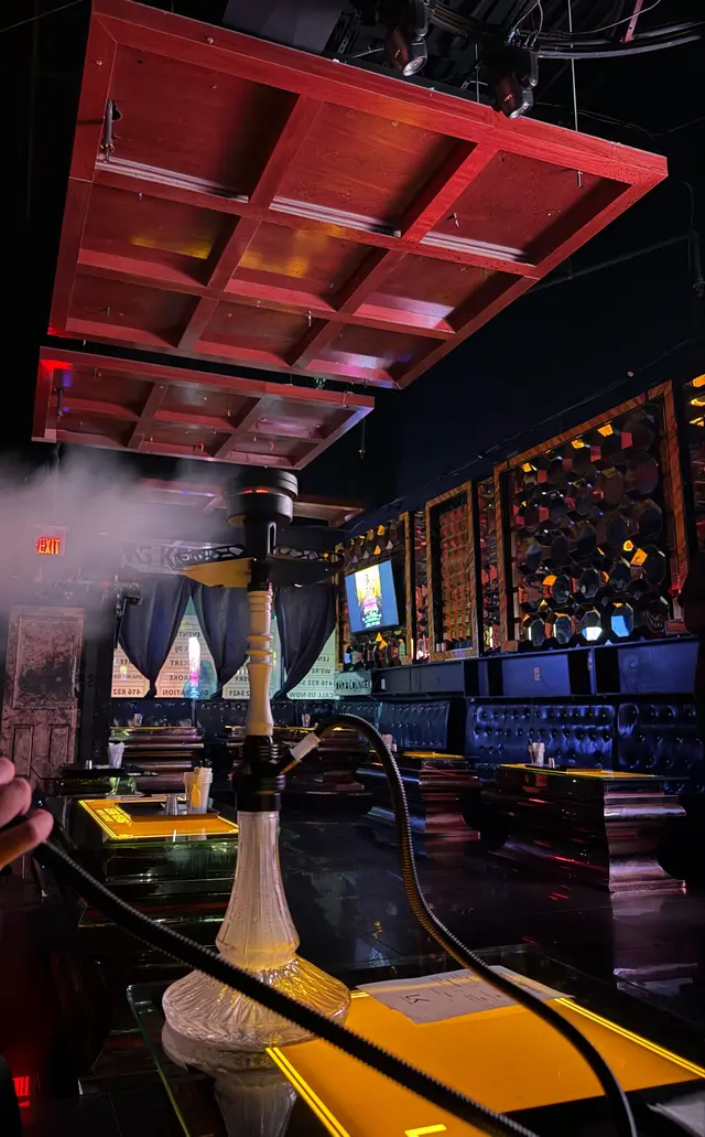 Lounge interior with a red-panelled ceiling and a hookah on the bar