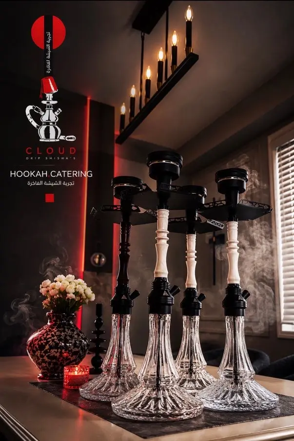 Four hookahs and flowers set out on a table indoors, Cloud Drip mark overlaid
