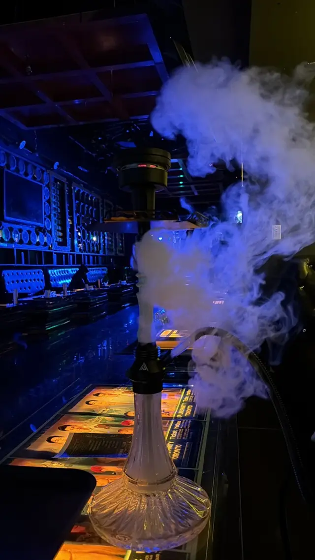 Hookah set up on the bar of a low-lit lounge, smoke drifting across the counter