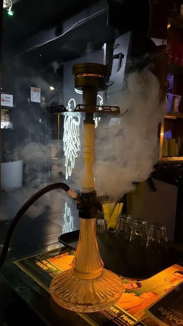Hookah on a bar counter, smoke rolling off the bowl
