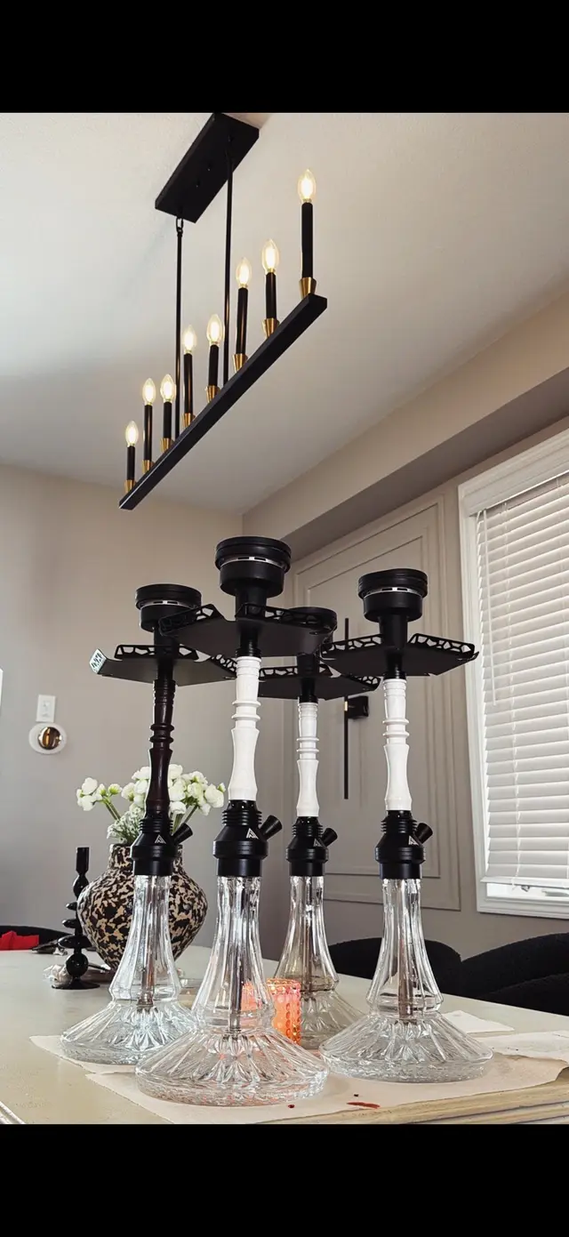 Four hookahs lined up on a dining table for an indoor party