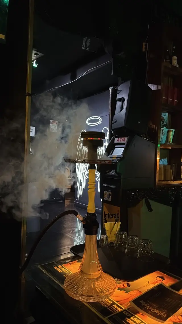 Hookah running on a bar counter, smoke lit from the side