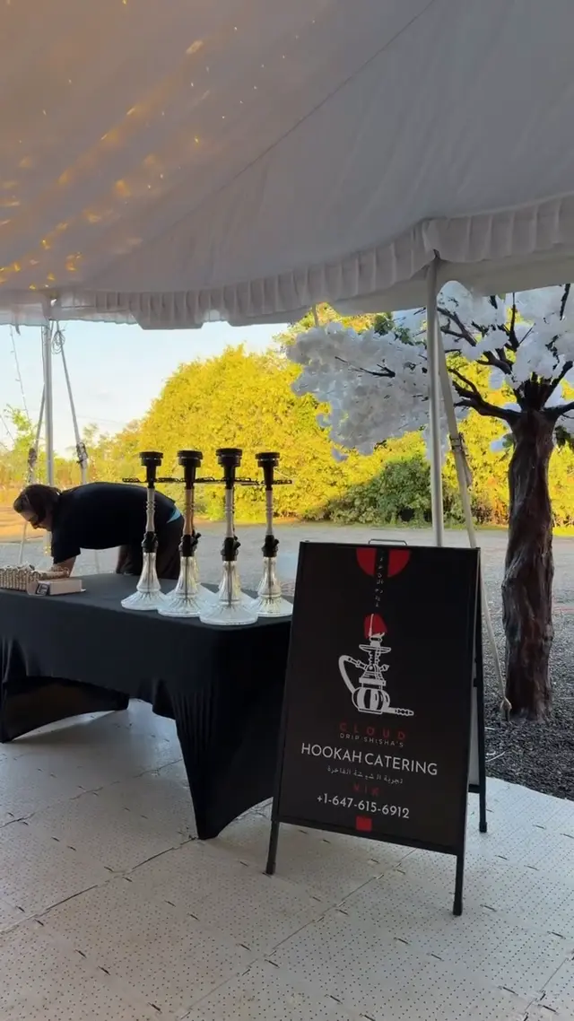 Row of hookahs on a draped table under a garden marquee
