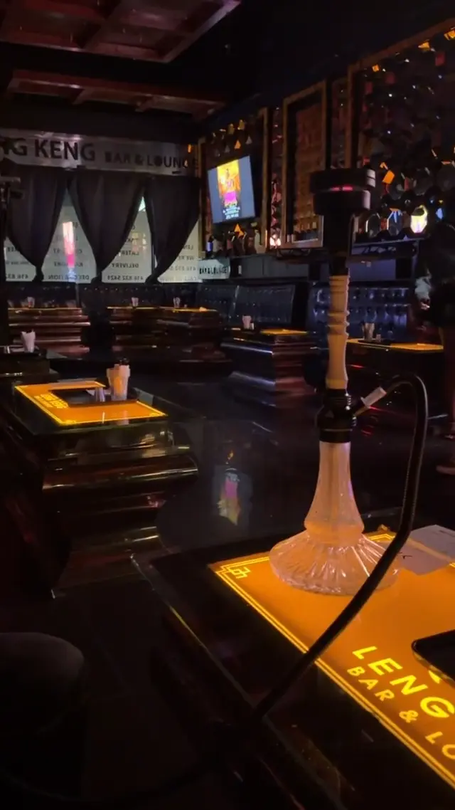 Hookah running on the bar of a low-lit lounge, smoke rolling across the counter