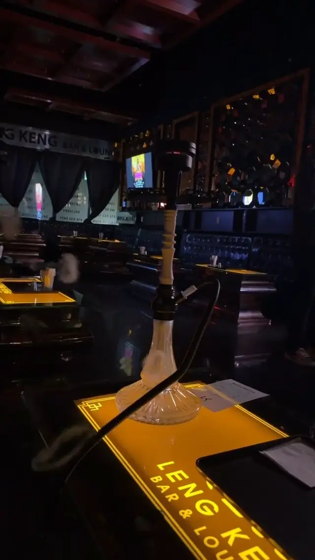 Hookah running on the bar of a low-lit lounge, smoke rolling across the counter