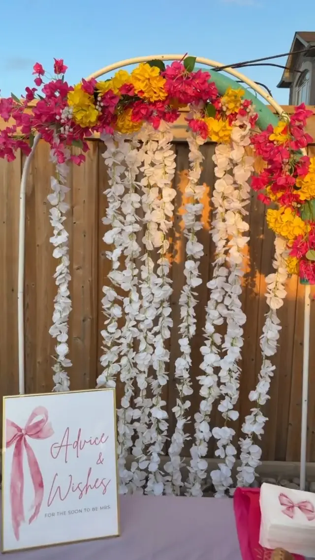 Floral backdrop and an advice-and-wishes table at a celebration