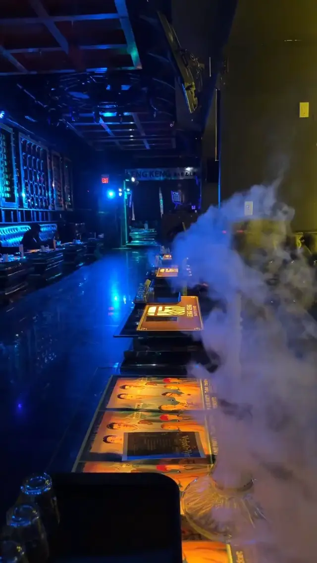 Hookah running on the bar of a low-lit lounge, smoke rolling across the counter