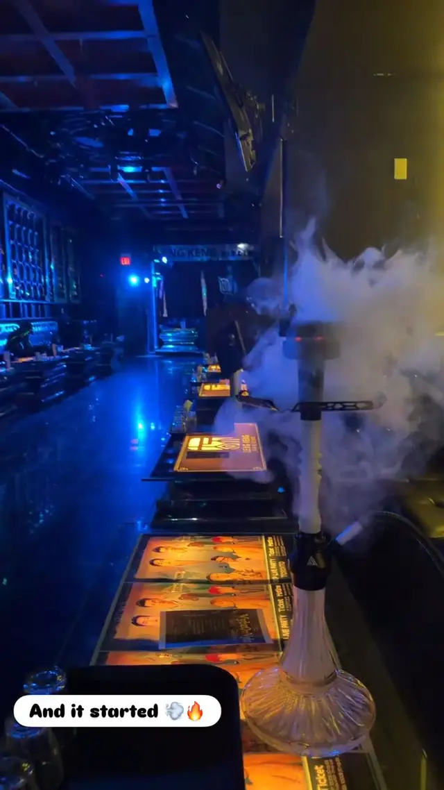 Hookah running on a lounge bar under blue neon, heavy smoke