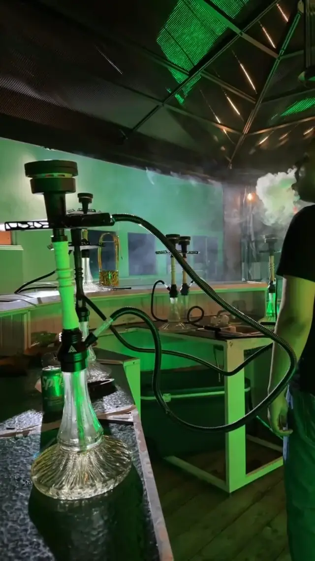 Hookah running under green light at an outdoor venue