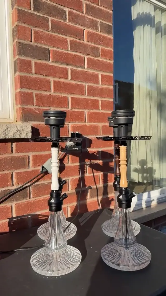 Four hookahs set up outdoors against a brick wall